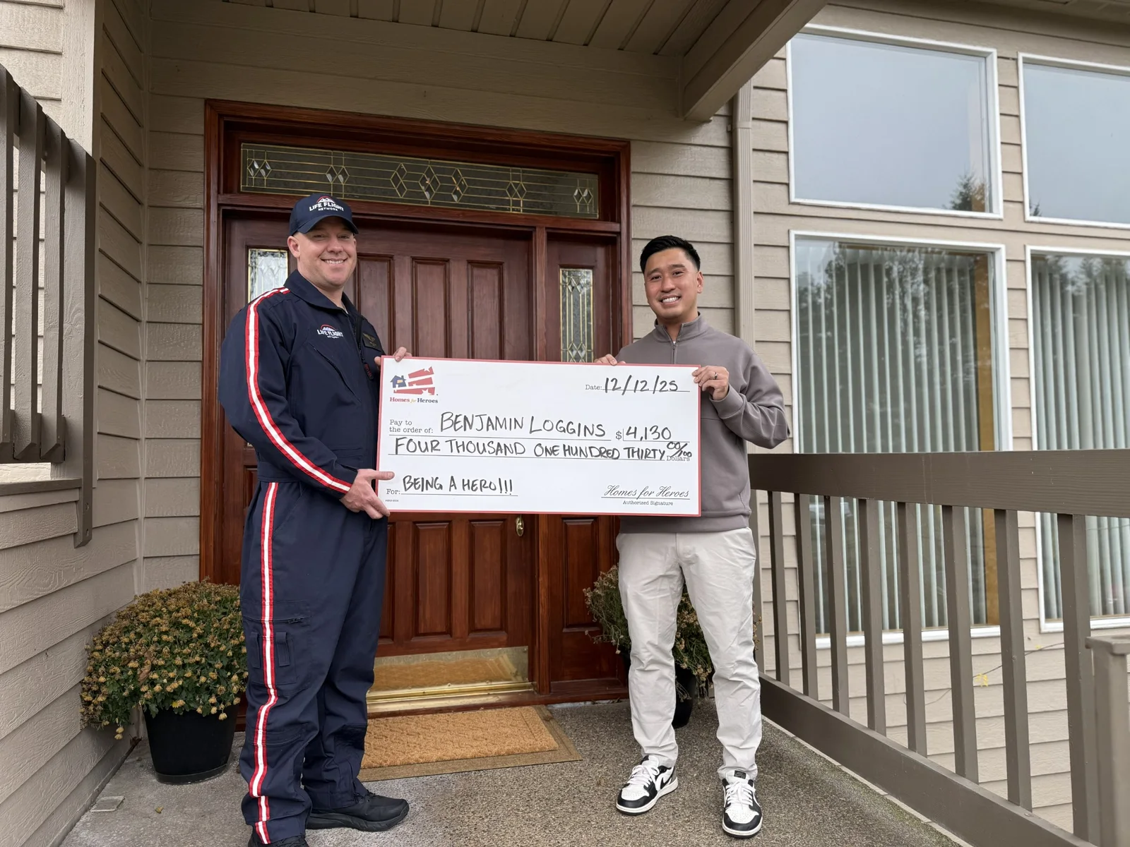 Daniel Chin with a first responder client holding a Homes for Heroes reward check