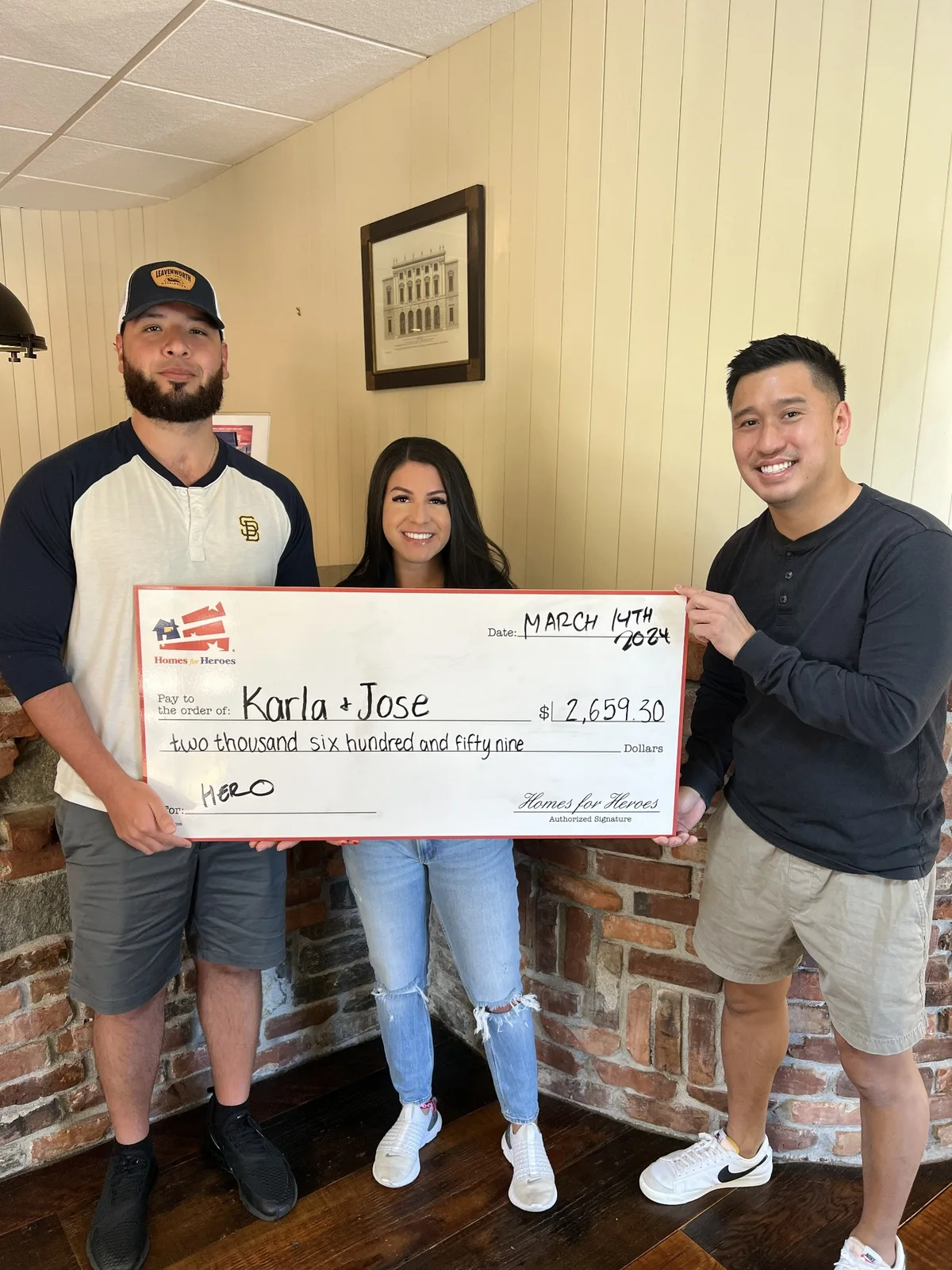 Daniel Chin with Homes for Heroes clients holding a reward check
