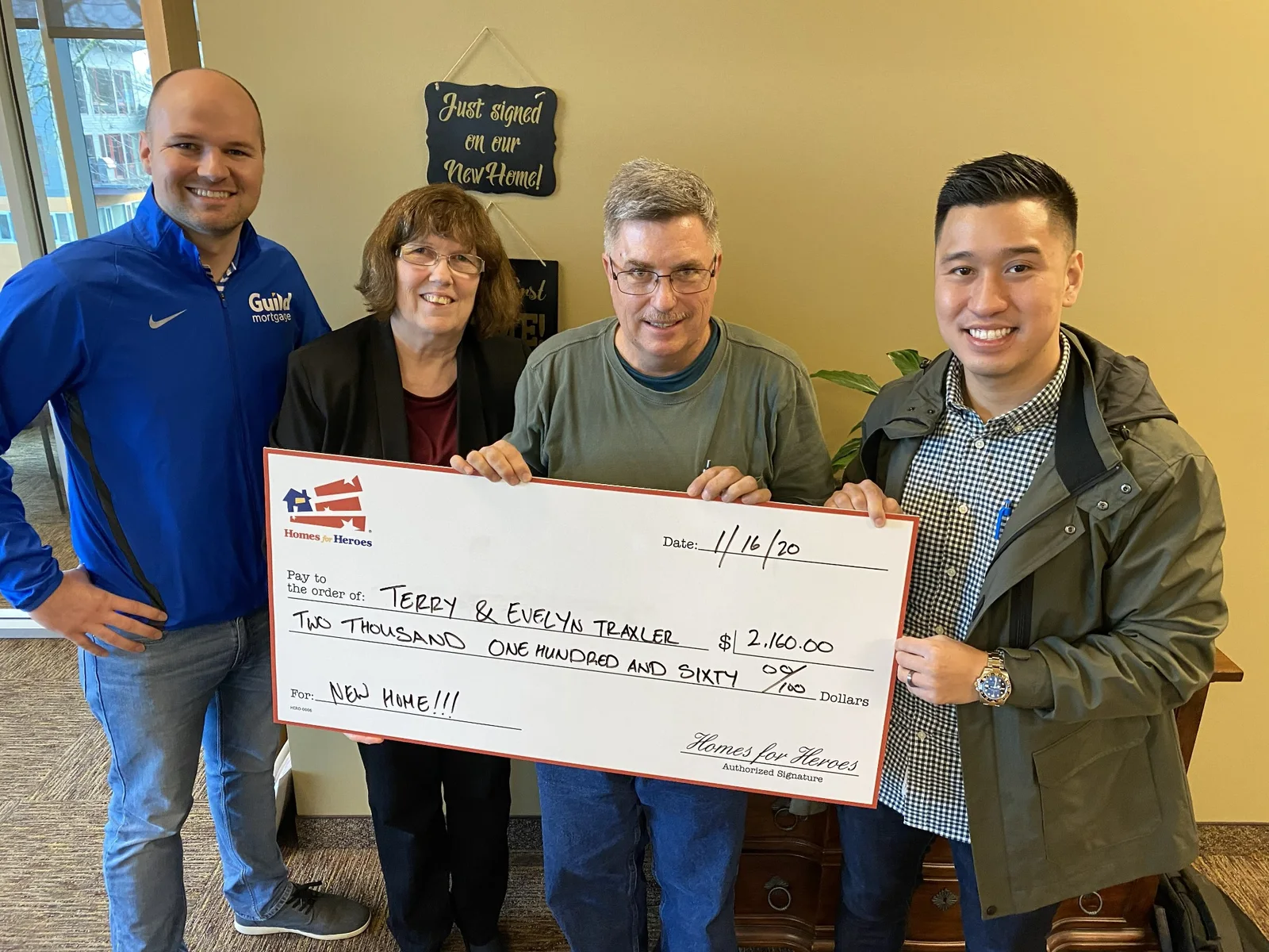 Daniel Chin with clients and a mortgage professional holding a Homes for Heroes reward check